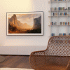 Beautifully framed art and photo display in a home library that also functions as a smart TV.